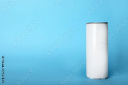 Can of energy drink on light blue background, space for text