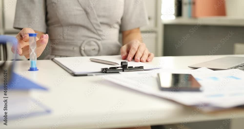 Business woman working with documents and flipping hourglass in office 4k movie slow motion Business woman working with documents and flipping hourglass in office 4k movie slow motion