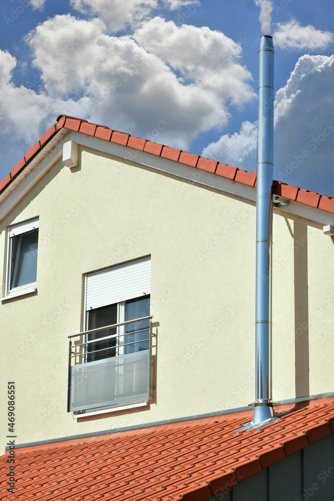 Fototapeta premium Schornstein, Außenkamin aus Edelstahl an der Fassade eines Wohnhauses