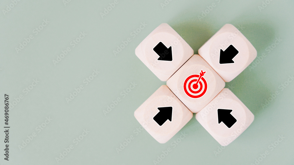 black arrow icons on wooden block around red dartboard for brainstorming, goal or target concept, with copy space black arrow icons on wooden block around red dartboard for brainstorming, goal or target concept, with copy space