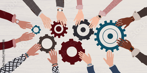 Group arms and hands of multicultural business people connecting and joining pieces of gears on a table. Concept of teamwork brainstorming or meeting between colleagues and co-worker