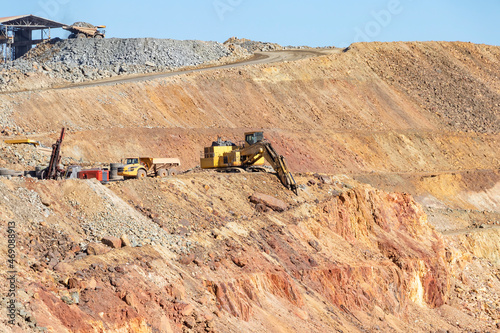 Mining trucks and machinery in Corta Atalaya open mine pit. Deep excavation of pyrite and extraction of minerals of cooper and gold in municipality of Minas de Riotinto, Huelva, Andalusia, Spain photo