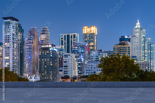 Panoramic Bangkok skyline view  concrete observatory deck on rooftop  night time. Asian corporate and residential lifestyle. Financial city downtown  real estate. Product display mockup empty roof