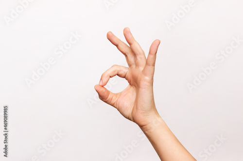 Female hand showing the ok gesture isolated on a white background. Okey hand sign photo
