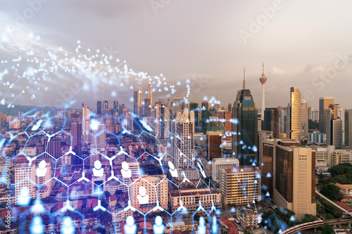 Photography Hologram of social media icons over sunset panoramic cityscape of Kuala Lumpur, Malaysia, Asia