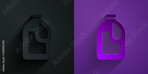 Paper cut Plastic bottle for laundry detergent, bleach, dishwashing liquid or another cleaning agent icon isolated on black on purple background. Paper art style. Vector