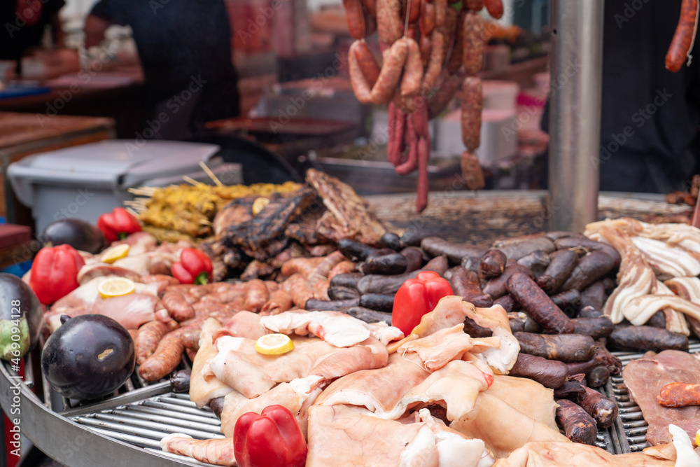 a large grill with different meats, sausages and vegetables on an open fire in the open air at a city festival dedicated to the Middle Ages