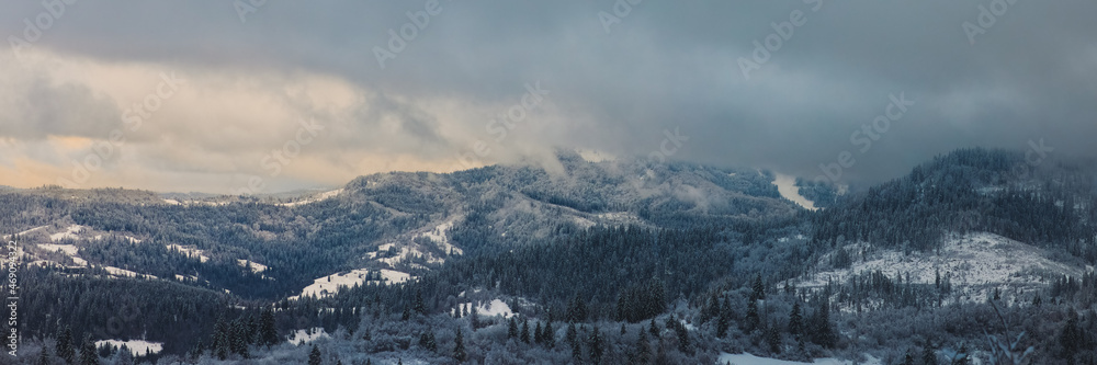 Christmas winter landscape with peaks and forest, on a foggy morning mountains. Beautiful panorama of winter forest. Carpathians Mountains, Ukraine
