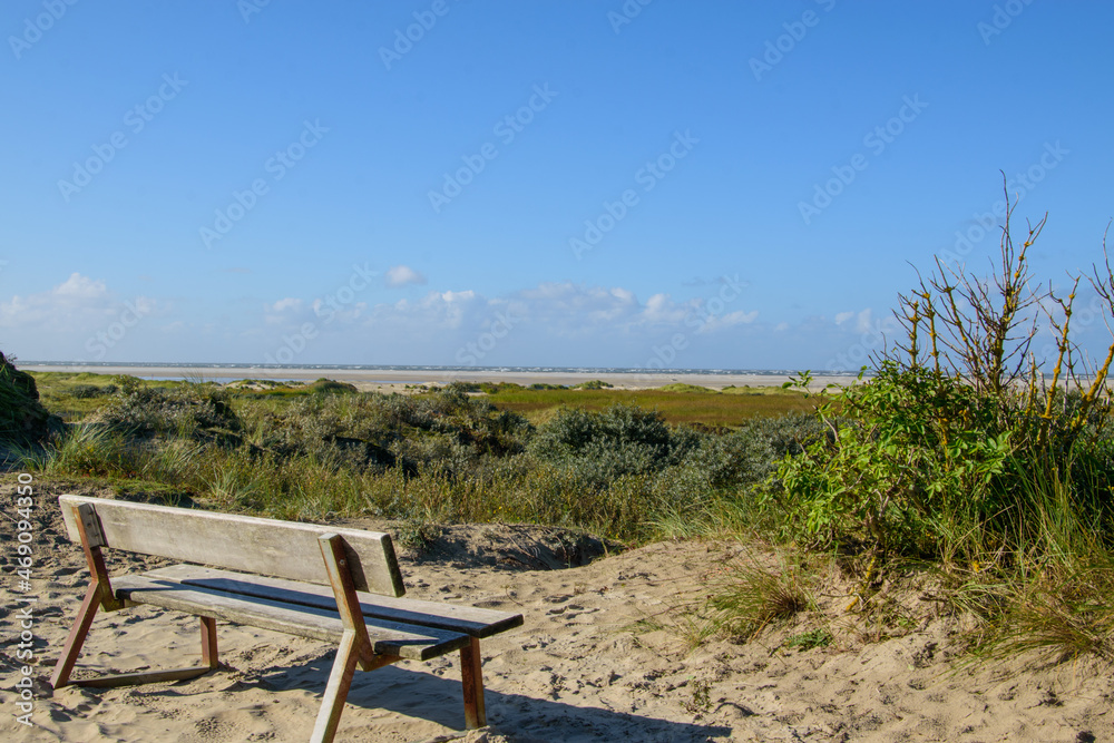 Bank an der Promenade der Nordseeinsel Borkum mit Blick über die Dünen auf das Meer. Bank an der Promenade der Nordseeinsel Borkum mit Blick über die Dünen auf das Meer.