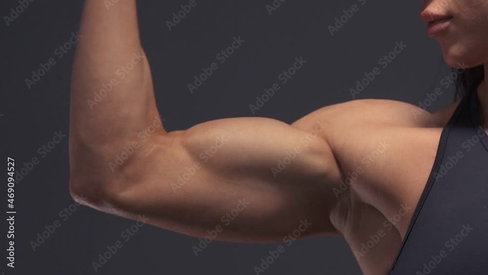 Muscular female bodybuilder woman workout arms: biceps and triceps in the gym. Sport and health care concept