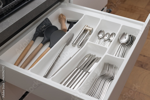 Open drawer with utensil set. Kitchen storage organization system. Modern kitchen photo