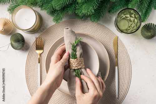 Woman preparing festive place setting. Festive table setting for Christmas dinner. top view