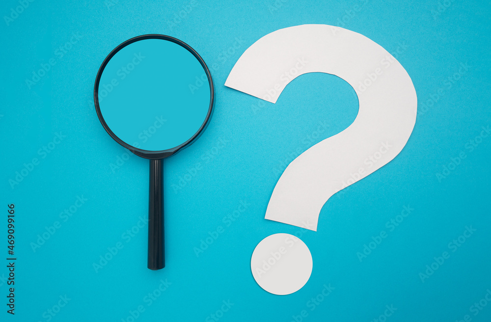 Search and question mark concept. A magnifying glass and a white question mark symbol are on a blue background. Top view. Space for text Search and question mark concept. A magnifying glass and a white question mark symbol are on a blue background. Top view. Space for text
