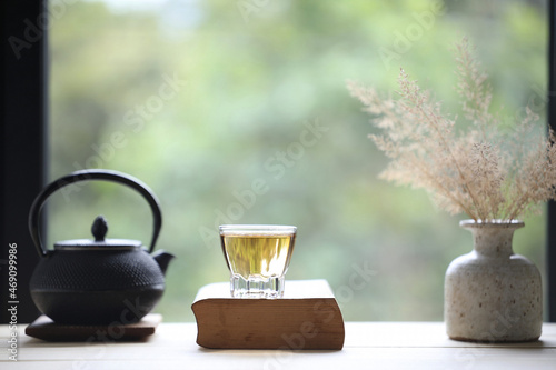 Glass tea cup and teapot and book