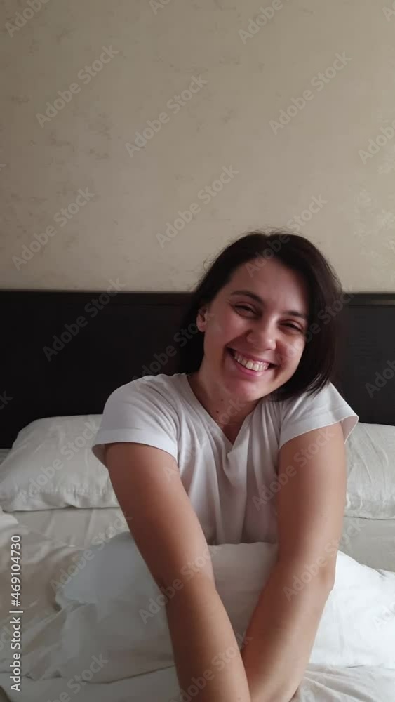 young happy woman waking up in bed morning time