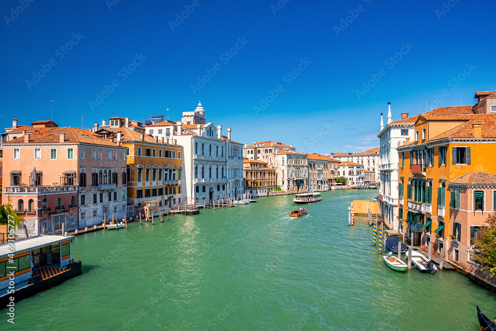 Scenic view of motorboats sailing in grand canal amidst historic residential buildings