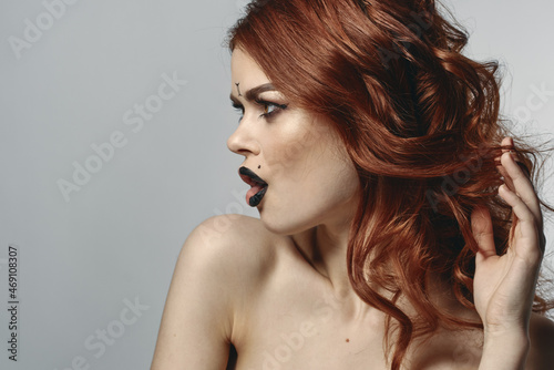 red-haired woman with bare shoulders bright makeup base zodiac sign horoscope