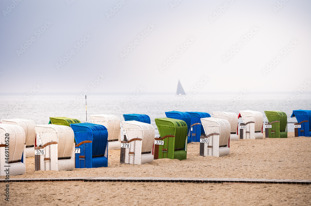 Green, blue and white strand baskets on the North Sea coast on the island of Föhr in hazy weather Green, blue and white strand baskets on the North Sea coast on the island of Föhr in hazy weather