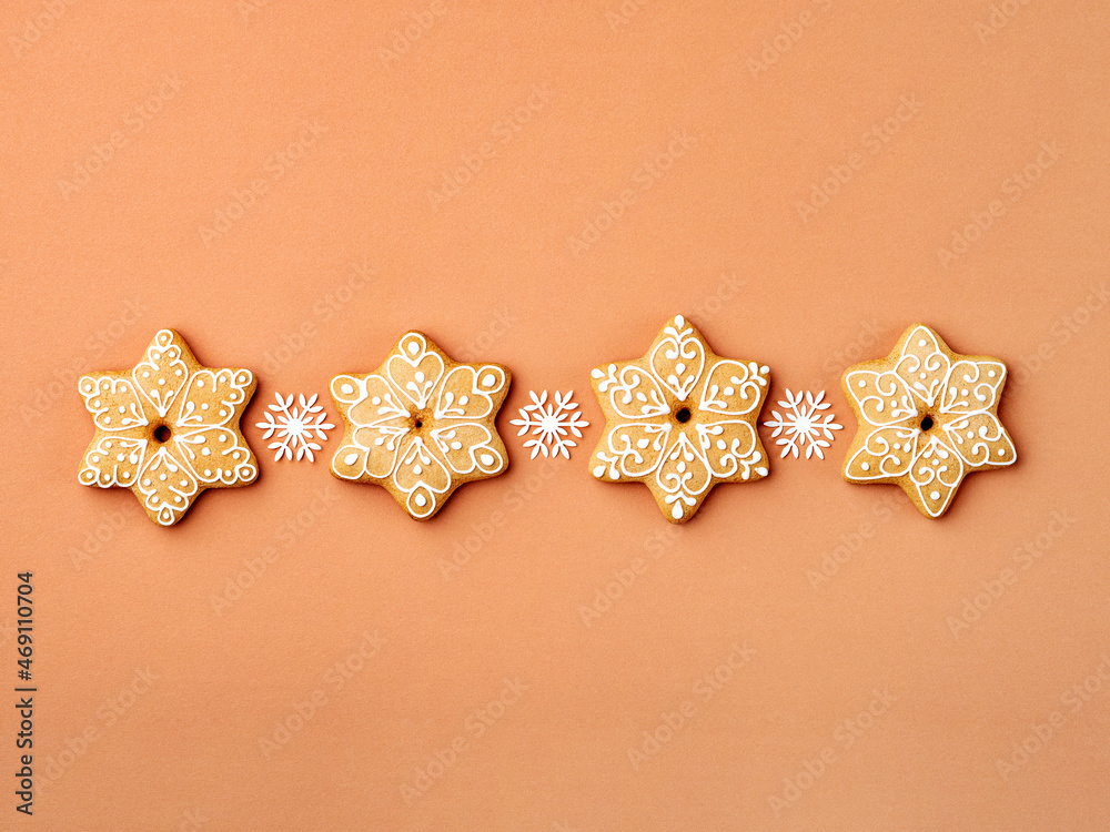Simple Christmas and New Year background with gingerbread cookies in a row. Homemade treats shaped as a snowflakes. Template for greeting card. Christmas, New Year and winter holidays concept. Simple Christmas and New Year background with gingerbread cookies in a row. Homemade treats shaped as a snowflakes. Template for greeting card. Christmas, New Year and winter holidays concept.