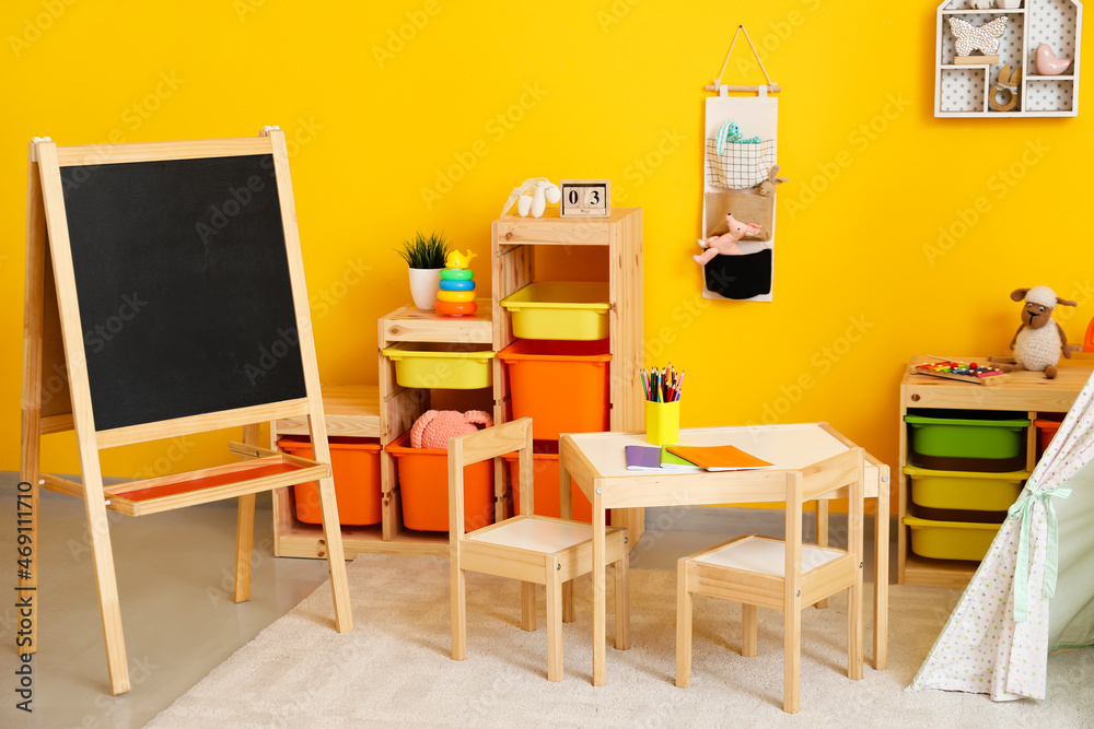 Stylish interior of modern children's room with table and chalkboard Stylish interior of modern children's room with table and chalkboard