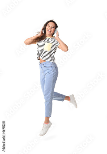 Jumping young African-American woman with headphones on white background