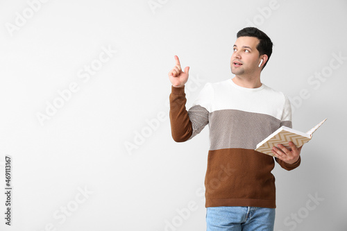 Young man with book and ear...