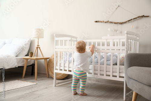 Bilde på lerret Adorable little baby standing near crib at home