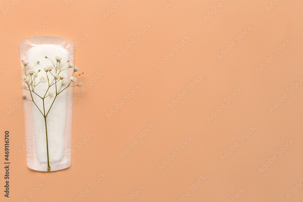 Menstrual pad and gypsophila flowers on color background