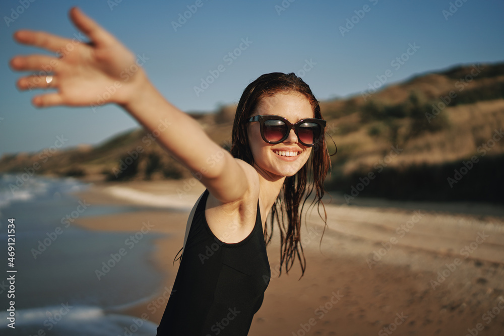 cheerful woman in a black swimsuit walking along the beach tropics summer cheerful woman in a black swimsuit walking along the beach tropics summer