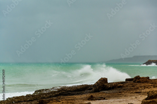 angry turquoise green color massive rip curl of a waves as it barrel rolls along the ocean. wild waves pound the coastline of chabahar in stormy day with cloudy sky close to coastline ,oman sea