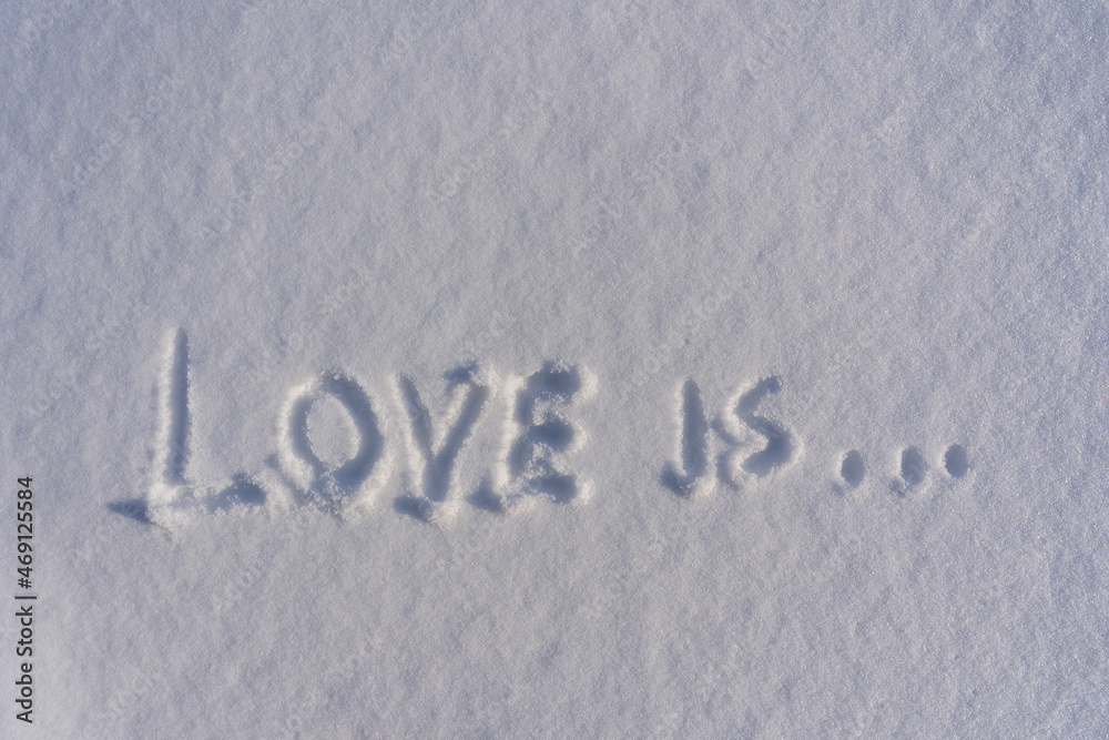 Text love is on a white fresh snow in winter, close up Text love is on a white fresh snow in winter, close up