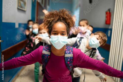 Group of school children wearing face masks in education center during Covid-19 pandemic.