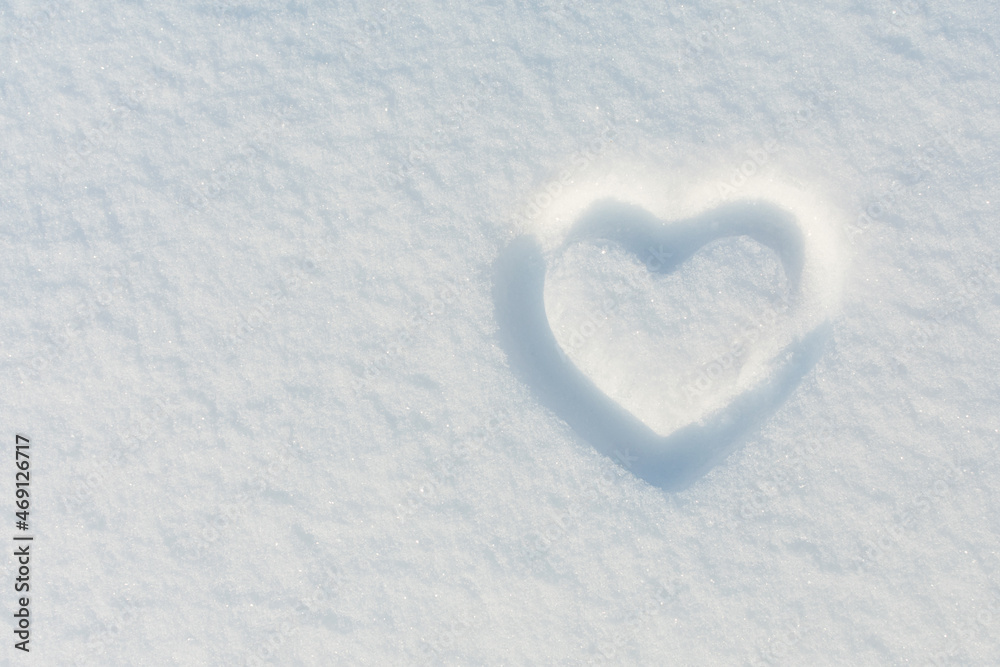 A heart shape squeezed into the white snow. The basis for the postcard. Place for an inscription.