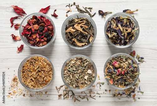 Flat lay composition with different dry teas on white wooden table