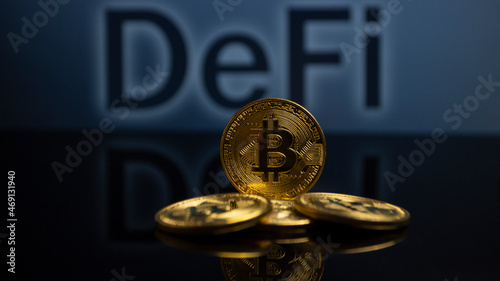 Cryptocurrency Bitcoin with the writing DeFi (decentralized finance) in the background photo