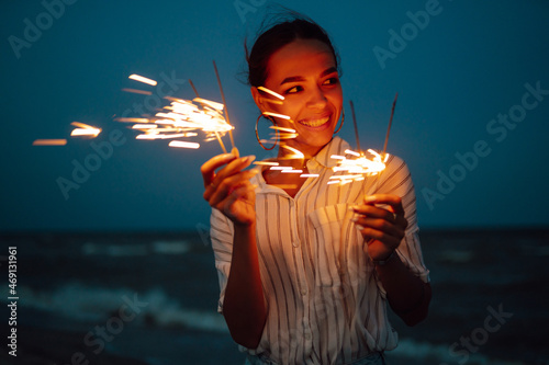 Female  hand holding burning Christmas sparkle on nature. Holidays, vacation, relax, travel and lifestyle concept.