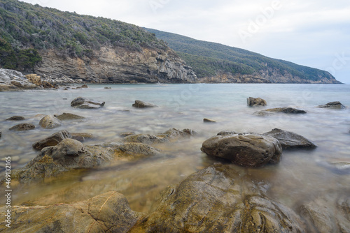 Felsen in der Bucca delle Fate mit Blick Richtung Isola del Elba, Toskana, Italien mit Wolken und Bergen