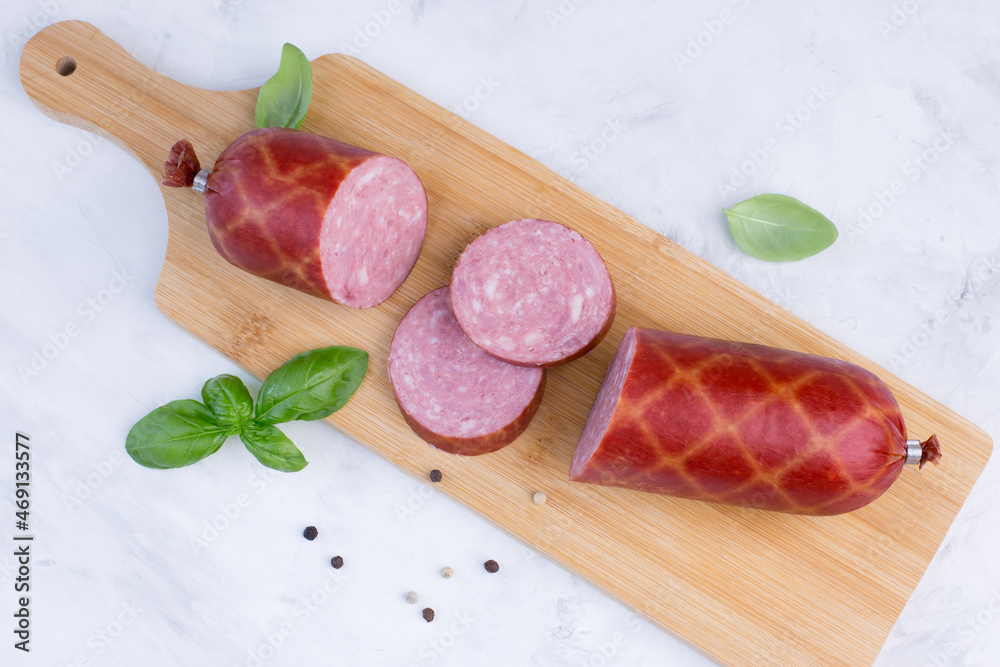 Sausage, basil and pepper on a wooden chopping board. Sausage, basil and pepper on a wooden chopping board.