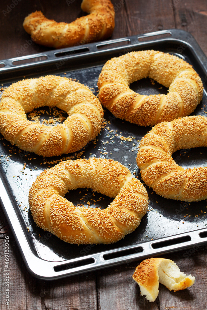 Traditional Turkish simits with sesame seeds on a wooden background. Rustic style. Traditional Turkish simits with sesame seeds on a wooden background. Rustic style.