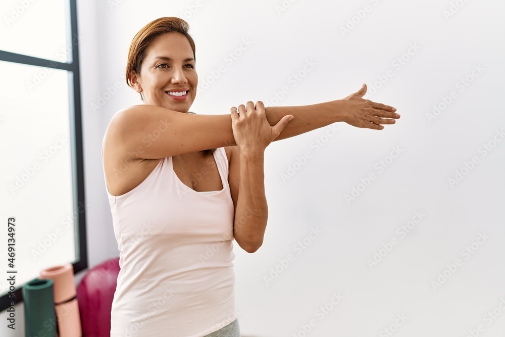 Young latin woman smiling confident stretching at sport center Young latin woman smiling confident stretching at sport center
