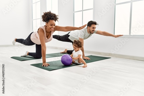Couple and daughter smiling confident training yoga at sport center