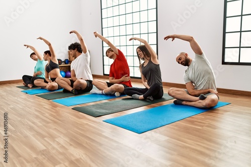 Group of young people concentrate training yoga at sport center.
