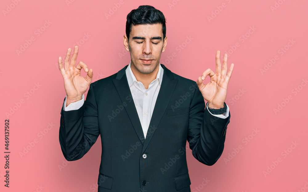 Handsome hispanic man wearing business clothes relaxed and smiling with eyes closed doing meditation gesture with fingers. yoga concept.