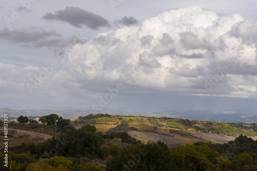 Blick über toskanische Landschaft im Herbst bei Sonnenschein und Wolken
