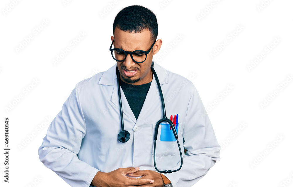 Young african american man wearing doctor uniform and stethoscope with hand on stomach because indigestion, painful illness feeling unwell. ache concept. Young african american man wearing doctor uniform and stethoscope with hand on stomach because indigestion, painful illness feeling unwell. ache concept.