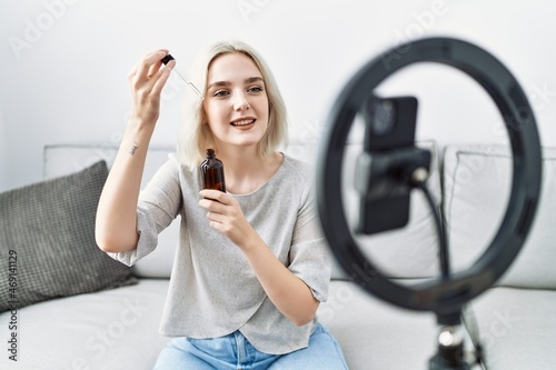 Young caucasian woman having video call using serum at home