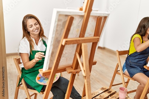 Mother and daughter smiling confident drawing at art studio