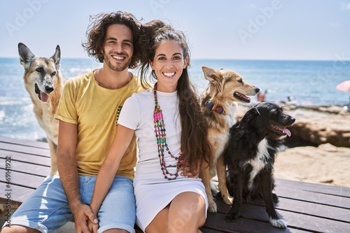 Photography Man and woman couple smiling confident hugging each other with dogs at seaside
