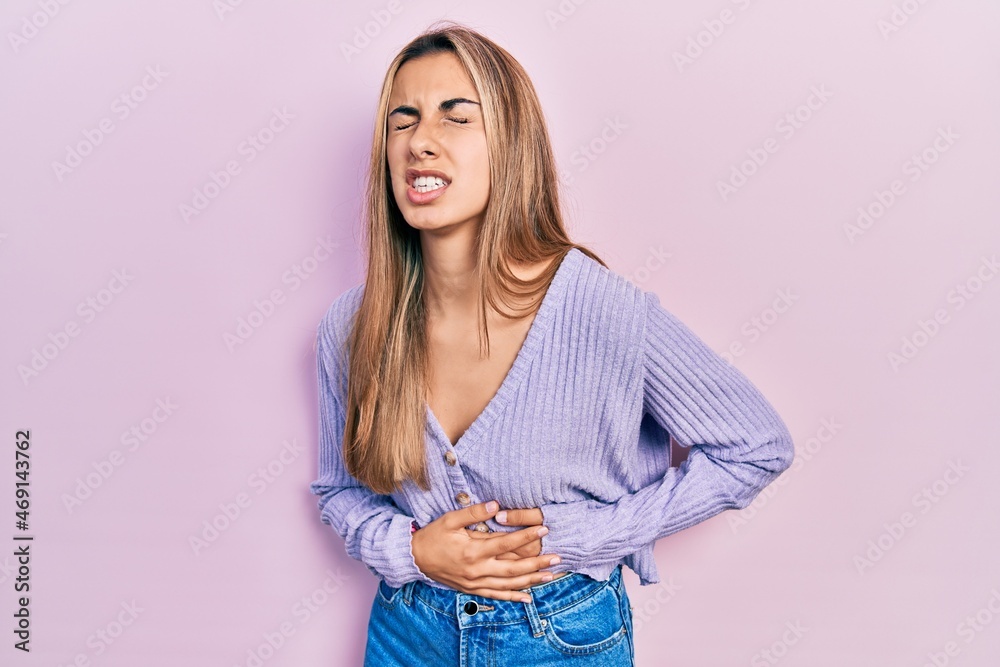 Beautiful hispanic woman wearing casual shirt with hand on stomach because nausea, painful disease feeling unwell. ache concept. Beautiful hispanic woman wearing casual shirt with hand on stomach because nausea, painful disease feeling unwell. ache concept.