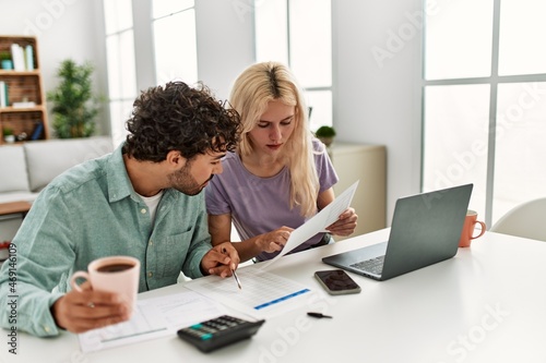 Young couple controlling family economy at home.
